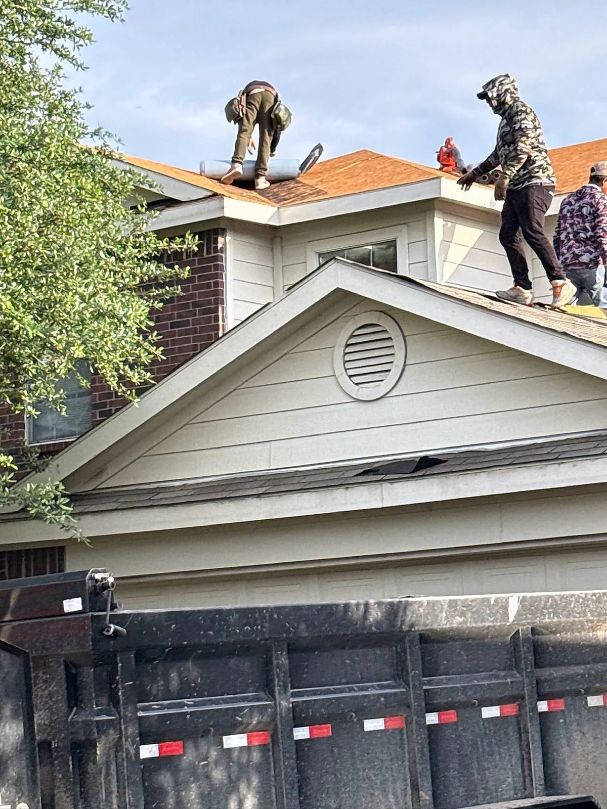 Crew working along the ridge above the garage