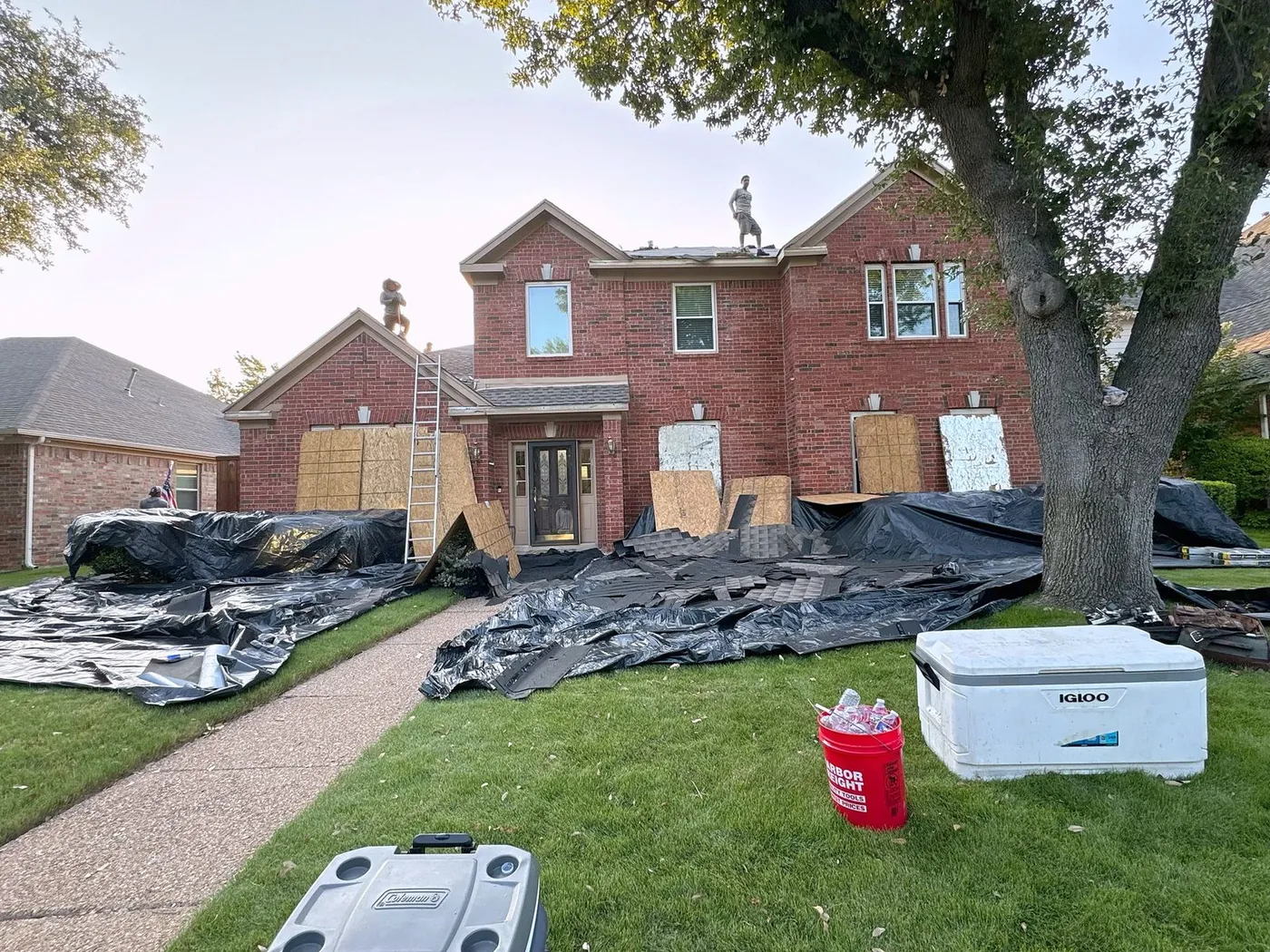 Plano home with tarps down and the roof replacement underway