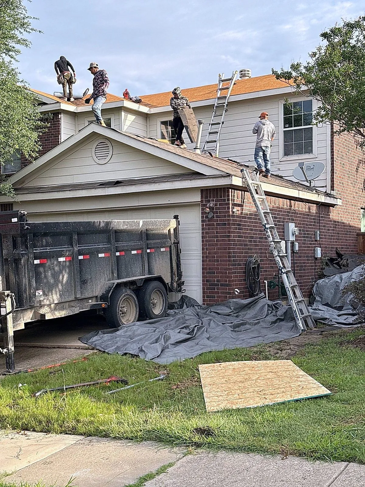 Crew and dump trailer at the front of the property