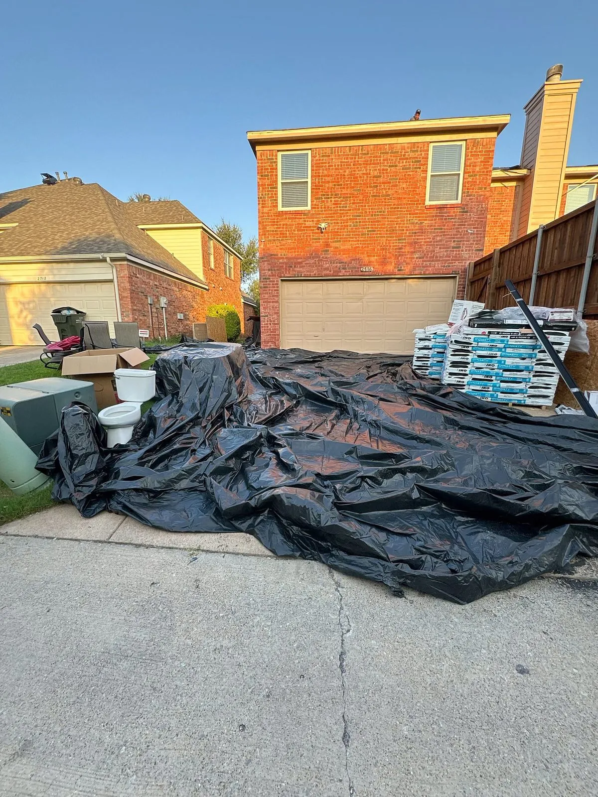 Debris tarps and material stacked on the driveway