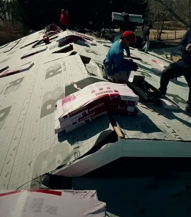 Peoples Construction crew installing underlayment on a roof